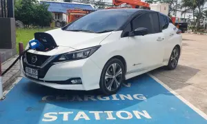 Vit Nissan Leaf 40 kWh laddas vid en laddstation.