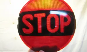 Rött stoppskylt med texten "STOP" i svarta bokstäver. En klassisk olja symbol för att stanna.