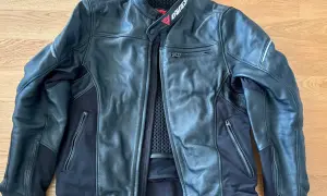Svart Dainese skinnjacka med dragkedjor och meshfoder. Perfekt för motorcykeläventyr.