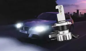 En bil med starka LED-lampor kör på natten. En ny LED-lampa visas i förgrunden, redo för en laglig konvertering.