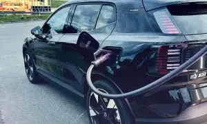 Svart elbil, troligen mest sålda elbilen, laddas vid en laddstation.