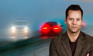 Man i kostym framför dimmig väg med bilar. Viktigt med dimljus regler för säkerhet.