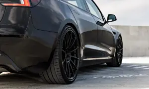 Svart Tesla Model 3 med blanka fälgar, redo för service.