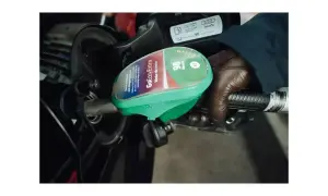En hand i brun handske håller i en bensinpump med texten "GoEasyExtra 98 Bensin E5". Bredvid syns en etikett med "95".