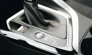 Detaljer från en bilinteriör: automatlådans växelspak, startknapp och parkeringsbroms. Dags att byta olja automatlåda för smidig körning.