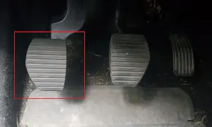 Kopplingspedalen i en manuell bil, markerad med röd ram. Denna pedal är avgörande för att växla.