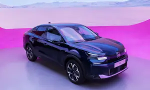 Mörkblå Citroën C4 elbil står på en grå yta med en rosa och lila bakgrund.