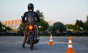 Motorcyklist i skyddsutrustning på en konbana, redo att öva.