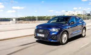 Mörkblå Audi Q3 kör på en motorväg i Sverige. Inga problem med denna bil, bara en härlig dag.
