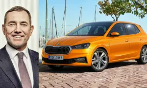 En leende man bredvid en orange Skoda Kamiq. Kanske är det en ny modell, eller så finns det ett Skoda Kamiq problem som diskuteras.