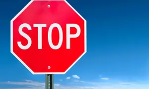 Rött stoppskylt mot blå himmel, en påminnelse om effektiv bromsning för säkerhet.