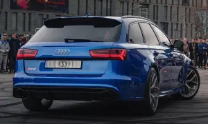 Blue Audi RS6 Avant with a crowd watching.