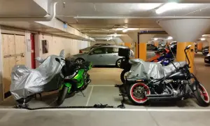 Här parkerar du moped klass 1: två motorcyklar, en grön och en svart, står i ett garage.