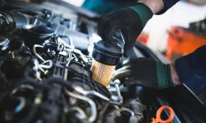 Mekaniker byter oljefilter vid oljebyte. Det är viktigt att man byter oljefilter vid oljebyte för att motorn ska må bra.
