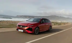 Röd Peugeot 308 kombi kör längs en kustväg. Inga problem med denna bil, bara en vacker vy.