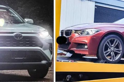 En vit Toyota och en röd BMW, båda med tända strålkastare. Kanske en jämförelse av hybridbil nackdelar?