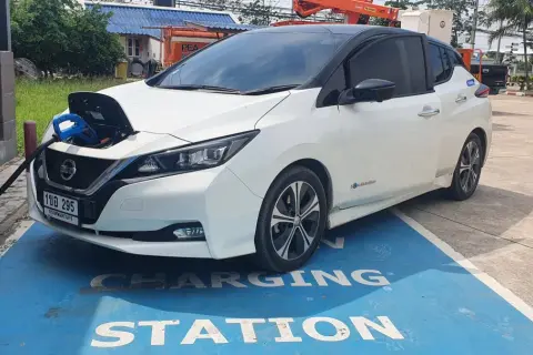 Vit Nissan Leaf 40 kWh laddas vid en laddstation.