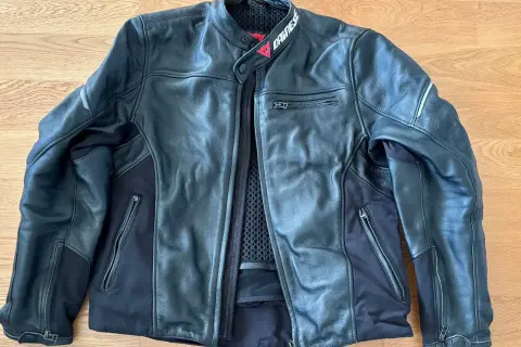 Svart Dainese skinnjacka med dragkedjor och meshfoder. Perfekt för motorcykeläventyr.