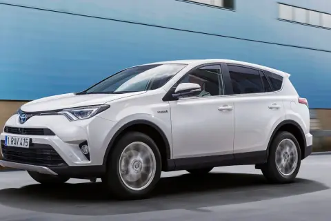 Vit Toyota RAV4 Hybrid körs på vägen, kanske med ett **toyota rav4 automat problem** som behöver åtgärdas.