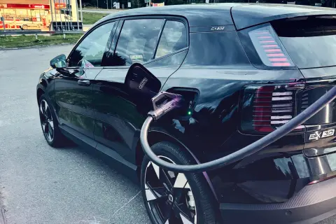 Svart elbil, troligen mest sålda elbilen, laddas vid en laddstation.