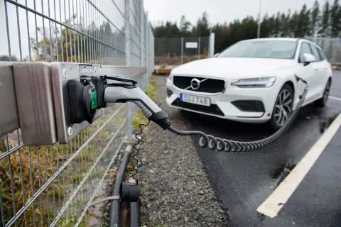 En vit Volvo laddas vid en laddstation. Perfekt för att hitta laddstationer när du är på språng.