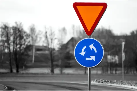 Varningsskylt för cirkulationsplats och väjningsplikt. Viktiga trafikregler frågor för säker körning.