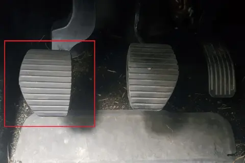 Kopplingspedalen i en manuell bil, markerad med röd ram. Denna pedal är avgörande för att växla.