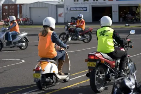 Personer på motorcyklar och mopeder övar körning. Perfekt för att plugga am kort gratis och bli en säker förare.