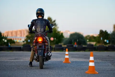 Motorcyklist i skyddsutrustning på en konbana, redo att öva.