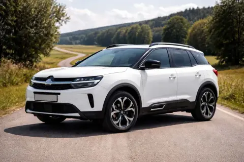 Vit Citroën C5 Aircross på en landsväg, redo för äventyr trots ett potentiellt citroën c5 aircross problem.