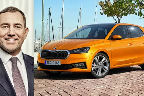 En leende man bredvid en orange Skoda Kamiq. Kanske är det en ny modell, eller så finns det ett Skoda Kamiq problem som diskuteras.
