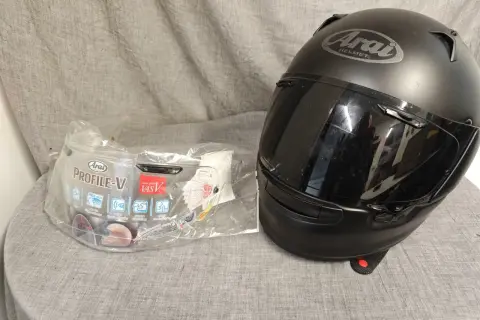 Svart Arai Profile-V hjälm med visir i förpackning. Perfekt för dig som söker en säker och bekväm hjälm.