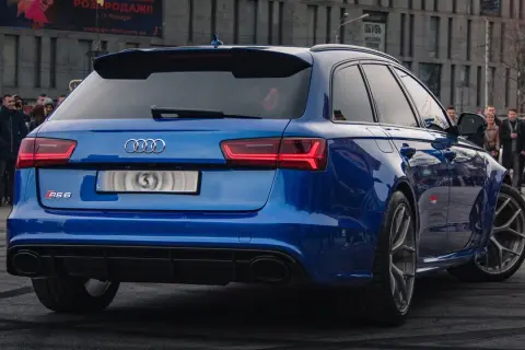 Blue Audi RS6 Avant with a crowd watching.