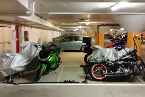 Här parkerar du moped klass 1: två motorcyklar, en grön och en svart, står i ett garage.