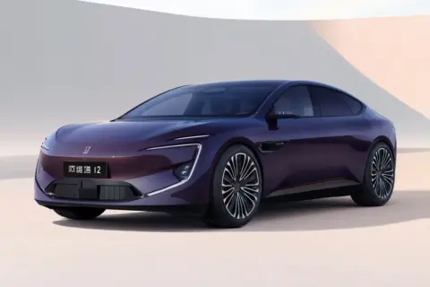 A sleek, dark purple electric sedan with distinctive LED headlights and a modern design.