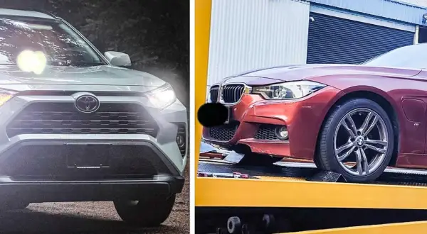 En vit Toyota och en röd BMW, båda med tända strålkastare. Kanske en jämförelse av hybridbil nackdelar?
