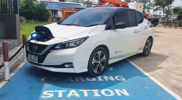 Vit Nissan Leaf 40 kWh laddas vid en laddstation.
