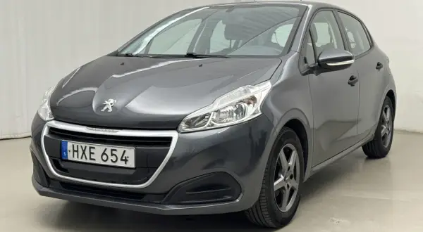 Mörkgrå Peugeot 208, HXE 654, står parkerad. Kanske en mindre peugeot 208 problem med lacken?