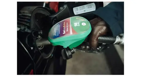 En hand i brun handske håller i en bensinpump med texten "GoEasyExtra 98 Bensin E5". Bredvid syns en etikett med "95".
