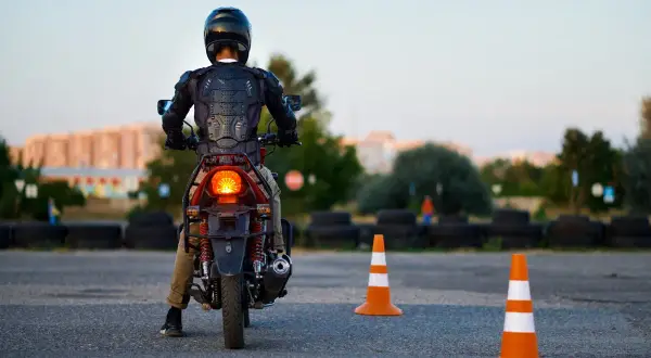 Motorcyklist i skyddsutrustning på en konbana, redo att öva.