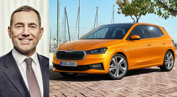 En leende man bredvid en orange Skoda Kamiq. Kanske är det en ny modell, eller så finns det ett Skoda Kamiq problem som diskuteras.