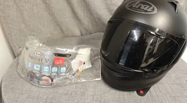 Svart Arai Profile-V hjälm med visir i förpackning. Perfekt för dig som söker en säker och bekväm hjälm.