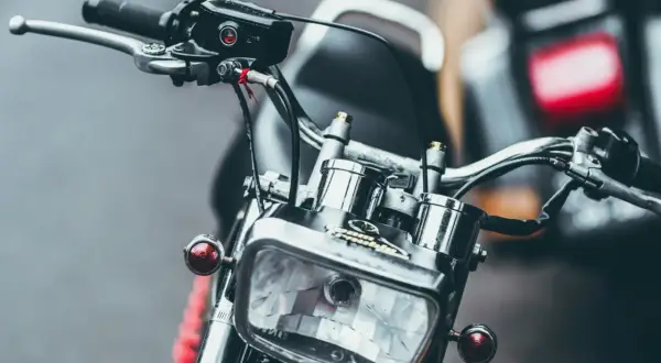 Detaljerad bild av en klassisk a1 motorcykel med kromade detaljer och en rektangulär strålkastare.