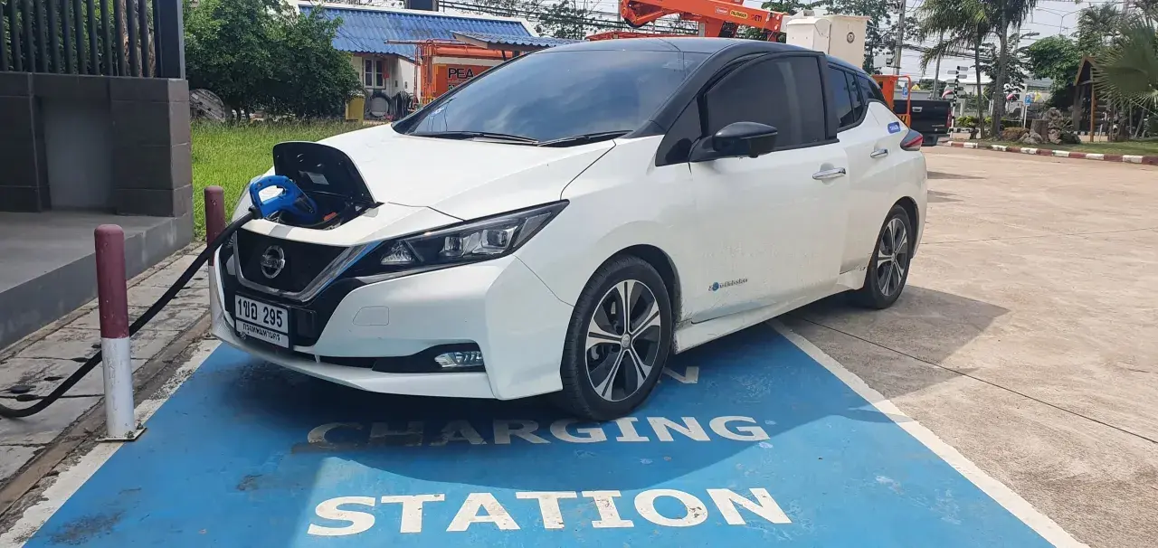 Vit Nissan Leaf 40 kWh laddas vid en laddstation.