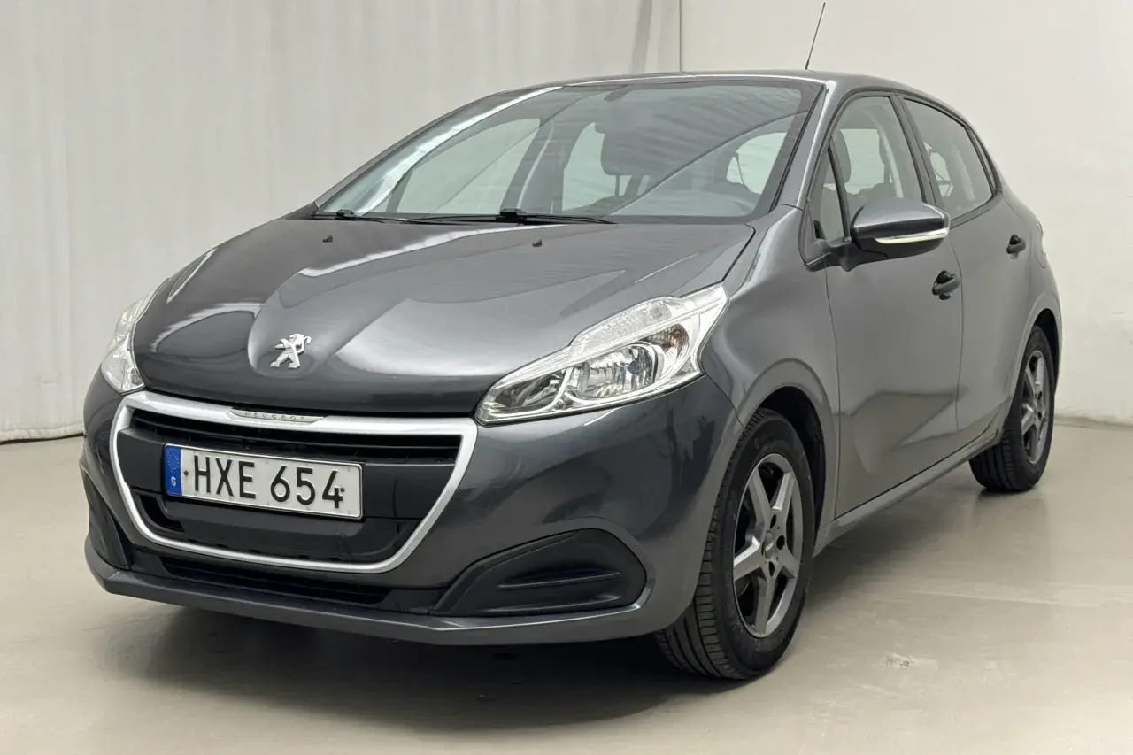 Mörkgrå Peugeot 208, HXE 654, står parkerad. Kanske en mindre peugeot 208 problem med lacken?