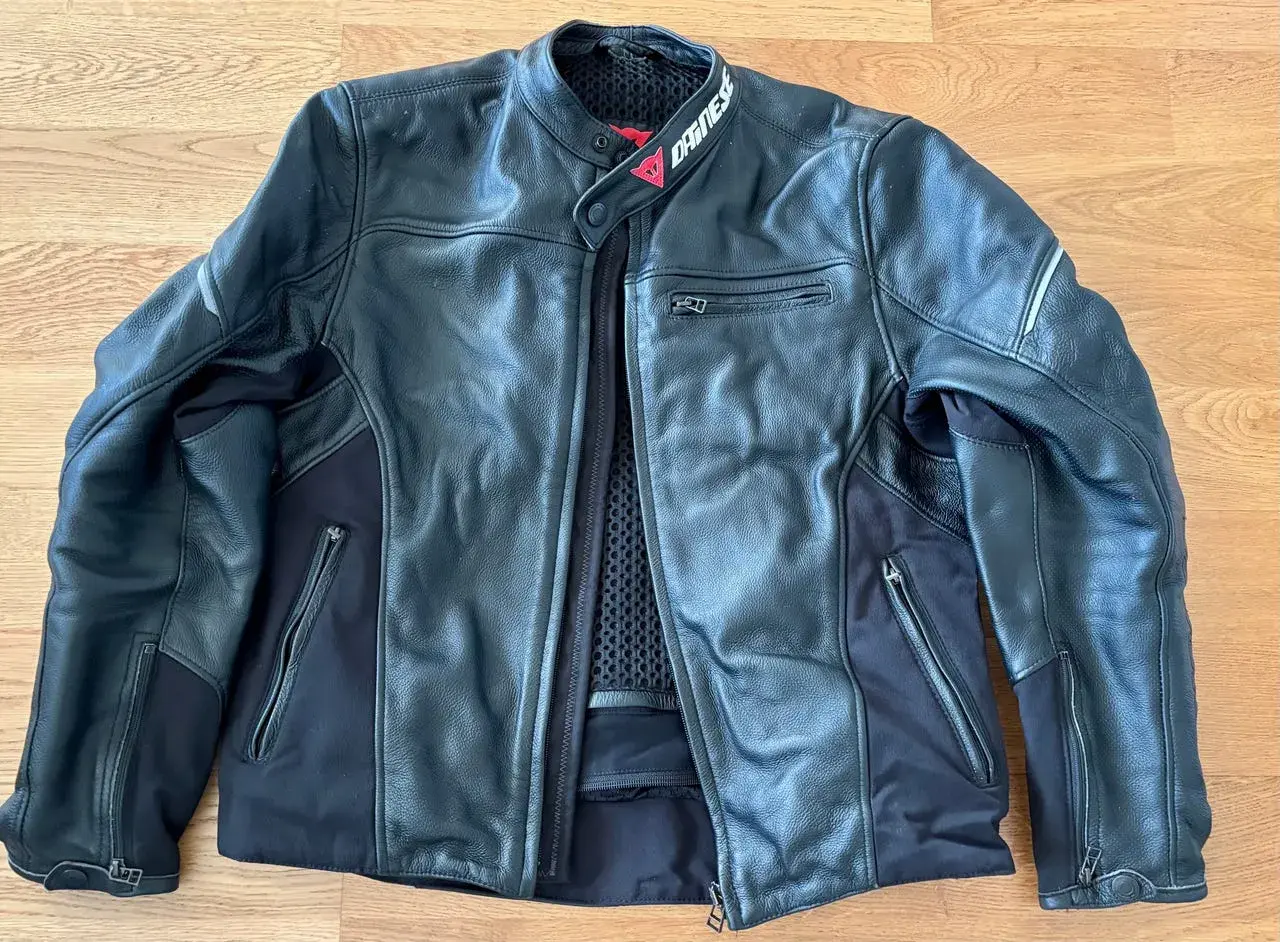 Svart Dainese skinnjacka med dragkedjor och meshfoder. Perfekt för motorcykeläventyr.