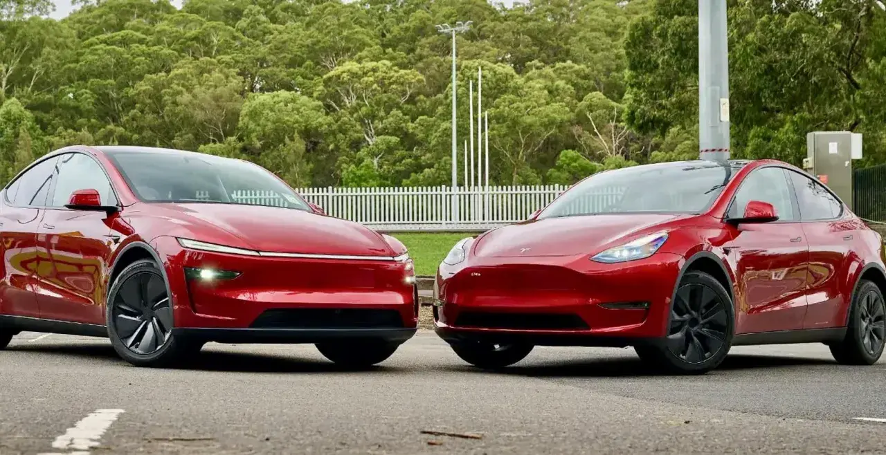 Två röda elbilar, en Tesla och en annan modell som påminner om en tesla juniper, står sida vid sida.