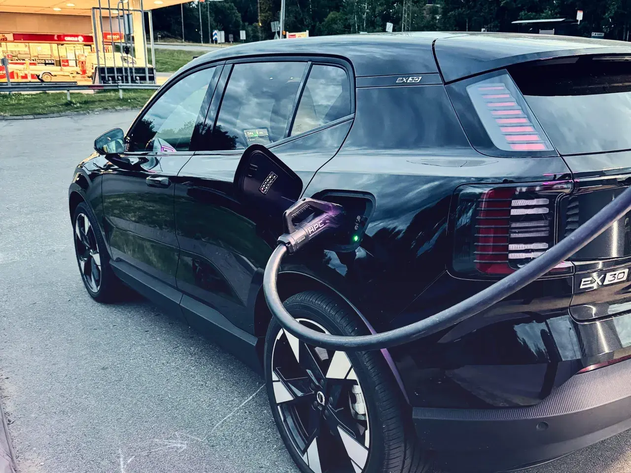 Svart elbil, troligen mest sålda elbilen, laddas vid en laddstation.