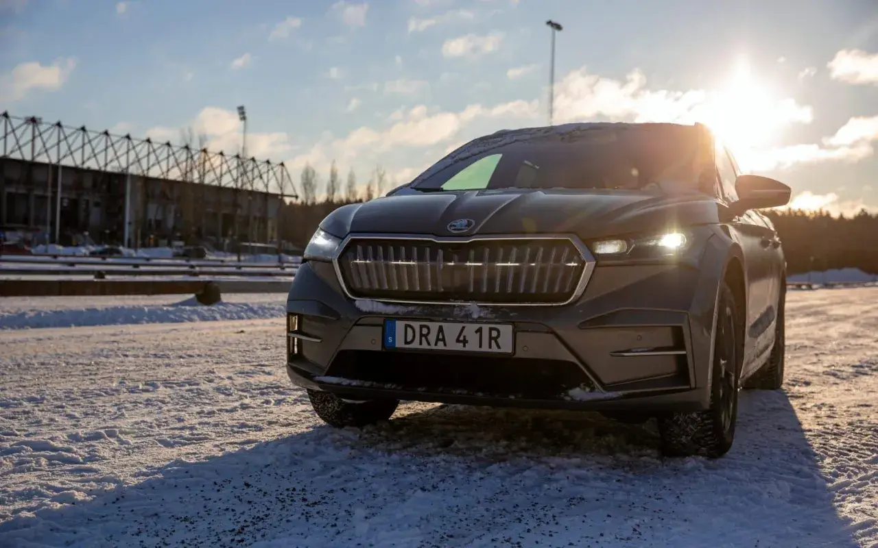 Skoda Enyaq 85x redo för vinterkörning i Sverige. Solen skiner över den snöiga marken.