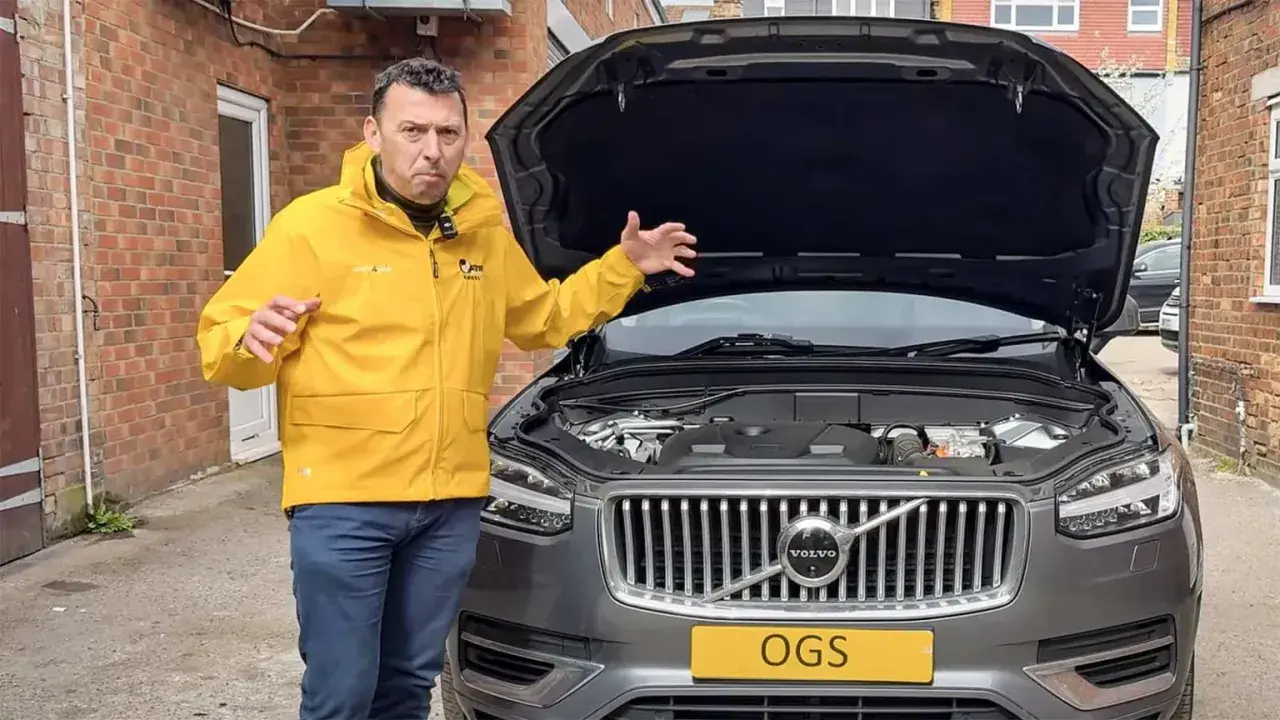 Man i gul jacka gestikulerar vid motorhuven på en Volvo XC60 som inte startar.